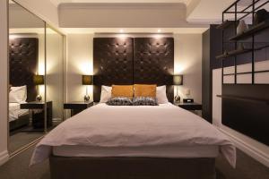 a bedroom with a large bed with a large headboard at CBD Executive Apartment right by the Harbour in Sydney