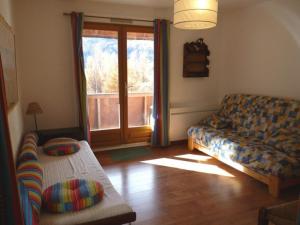 uma sala de estar com um sofá e uma janela em Appartement Les Orres, 3 pièces, 8 personnes - FR-1-322-586 em Les Orres