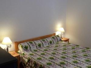um quarto com uma cama com colcha floral e 2 candeeiros em Appartement Les Orres, 3 pièces, 8 personnes - FR-1-322-586 em Les Orres