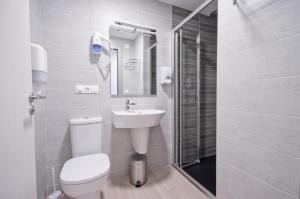 a bathroom with a toilet and a sink and a shower at Hotel Ferramenteiro de Portomarin in Portomarin