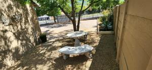 two tables with seats sitting next to a tree at Cottage Rose in Bloemfontein +1 photo