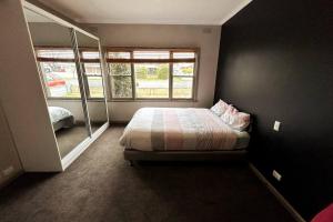a bedroom with a bed and a large window at Maryborough Central Home in Maryborough