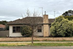 a brick house with a tree in front of it at Maryborough Central Home in Maryborough