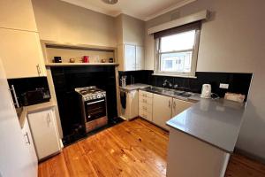 a kitchen with white cabinets and a stove top oven at Maryborough Central Home in Maryborough