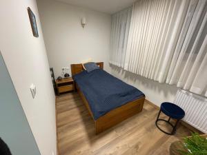 a small bedroom with a bed with a blue blanket at Pałac Zbylitowskich in Zbylitowska Góra