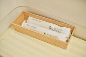 a wooden box filled with towels on a bed at TORA HOTEL Tokyo Ueno 寅ホテル 上野 D in Tokyo