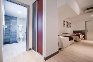 A bed or beds in a room at Hotel Ferramenteiro de Portomarin