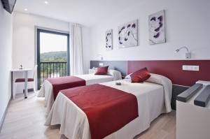 A bed or beds in a room at Hotel Ferramenteiro de Portomarin