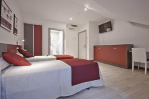 A bed or beds in a room at Hotel Ferramenteiro de Portomarin