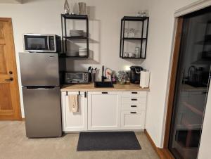 a kitchen with white cabinets and a refrigerator at Park-like setting in-law apartment less than a mile to Evergreen in Evergreen