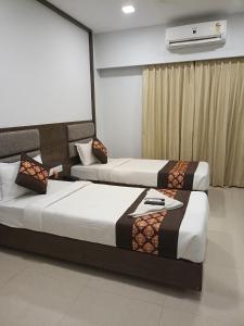 two beds in a hotel room with at Hotel Zain Grande in Chennai