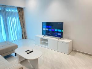 a living room with a large flat screen tv at Eaton Residences at Leo in Kuala Lumpur