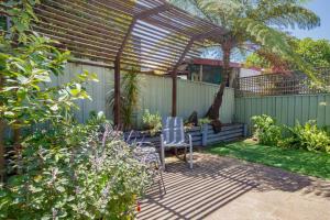 pérgola con mesa y sillas en un jardín en 'The Elizabeth' A Romantic Garden Retreat for Two en Newcastle