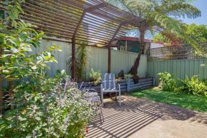 a pergola with a table and chairs in a garden at 'The Elizabeth' A Romantic Garden Retreat for Two in Newcastle