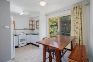 a kitchen with a wooden table and a dining room at 'The Elizabeth' A Romantic Garden Retreat for Two in Newcastle