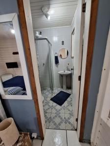 a bathroom with a shower and a toilet and a sink at Canto Boreal - Suítes e Estúdios in Camburi