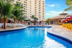 uma piscina num hotel com cadeiras e guarda-sóis em Golden Dolphin GRAND HOTEL - Apartamento COM VISTA em Caldas Novas