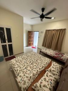 a bedroom with two beds and a ceiling fan at D’solok chalet in Kampong Pantai Ayer Hitam