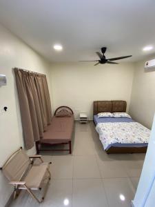 a bedroom with two beds and a ceiling fan at D’solok chalet in Kampong Pantai Ayer Hitam