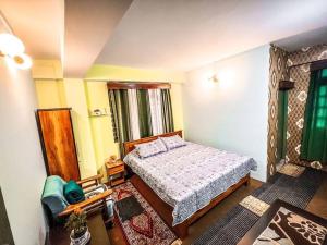 a small bedroom with a bed and a chair at Stay Cation “live like a local” in Gangtok