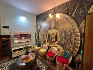 a living room with a large mural of a buddha at Stay Cation “live like a local” in Gangtok
