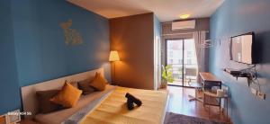 a bedroom with a bed with a cat sitting on it at Peony's Home in Ban Don Muang (1)