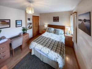 una camera con letto, scrivania e letto Sidx Sidx Sidx di Apple Tree Cottage a Threlkeld