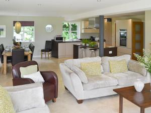 a living room with a couch and a kitchen at Lock Cottage in Aylsham