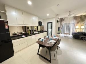 Eaton Residences at Leo في كوالالمبور: مطبخ وغرفة معيشة مع طاولة فيها