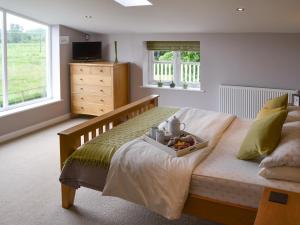 um quarto com uma cama com uma bandeja de comida em Lock Cottage em Aylsham