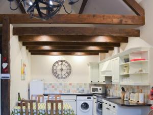 a kitchen with white appliances and wooden beams at Rook in Broadhempston