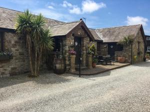 a stone building with palm trees in front of it at The Willows in Parkmill