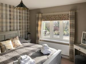 a bedroom with a bed and a window with towels on it at Carr House in Cayton