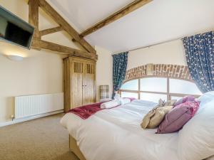 a bedroom with a large bed with pillows on it at Gorst Farm Barn in Great Eccleston