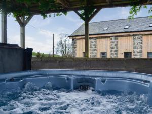 a hot tub in the backyard of a house at Kris Kin in Brynkir