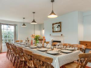 a long dining room with a long table and chairs at Park Farmhouse in Chideock