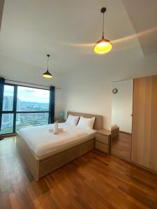 een slaapkamer met een groot bed en een groot raam bij Eaton Residences at Leo in Kuala Lumpur