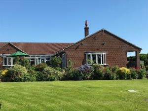 a brick house with a lawn in front of it at Carr House in Cayton