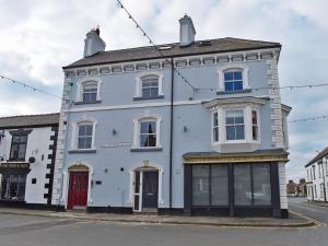 a white building with a red door on a street at Sir Nigel Gresley in Flamborough