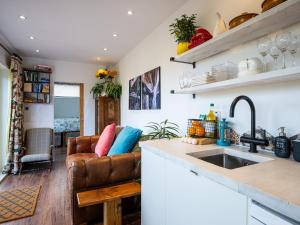 a kitchen with a couch and a sink at Sunrise Cabin in East Ilsley