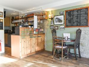 a restaurant with a table and chairs and a chalkboard at Hideaway Studio Apartment in Denby Dale