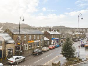 a town with cars parked on a street with a bridge at Hideaway Studio Apartment in Denby Dale