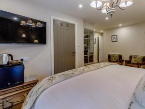 a bedroom with a large bed and a tv at The Grousemoor in Llandegla