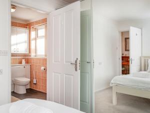 a bathroom with a bed and a toilet in a room at Bay Tree in Porthscatho