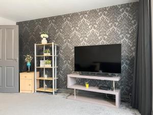 a living room with a flat screen tv on a wall at Royal House in Ilkeston