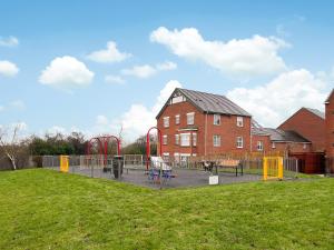 un parque infantil frente a un edificio con césped en Royal House, en Ilkeston