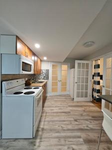 una cocina con electrodomésticos blancos y armarios de madera en Oakridge, en North Bay