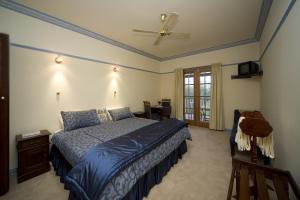 1 dormitorio con 1 cama y ventilador de techo en Wombatalla en Kangaroo Valley