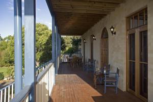 un porche de una casa con mesa y sillas en Wombatalla en Kangaroo Valley