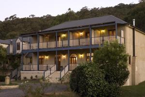 a large house with a balcony with lights on it at Wombatalla in Kangaroo Valley